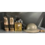 Two miner's lamps, a gas mask and a military helmet.