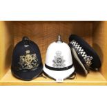 A white police helmet for the Isle of Man, together with a two further police caps.