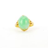 A yellow metal (tested 18ct gold) ring set with cabochon cut jade, (P).