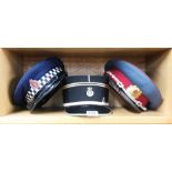 A French Police cap, a New Zealand police cap and one other.