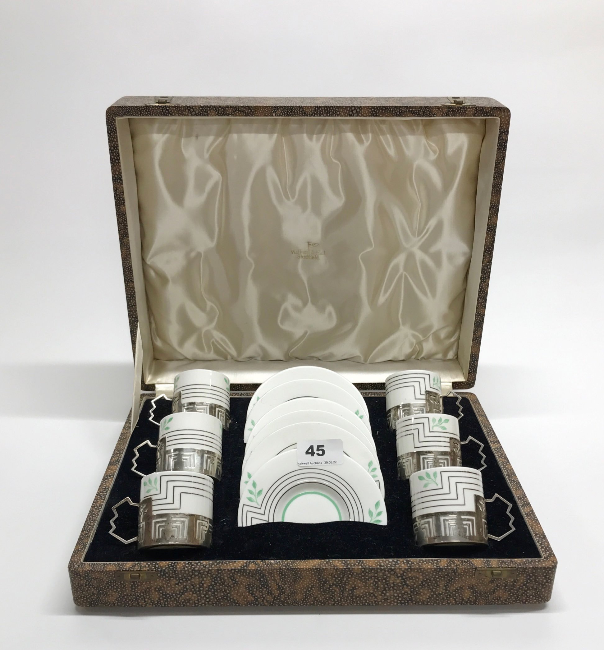 A boxed set of six Wedgwood porcelain coffee cups with hallmarked silver cup holders.