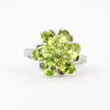 A 925 silver ring set with round and oval cut peridot, (Q).