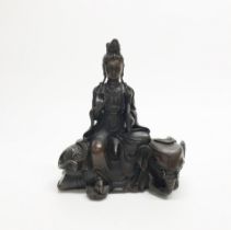 A Chinese bronze figure of the Goddess Guanyin seated on an elephant, H. 22cm.