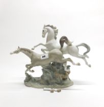 A Lladro porcelain figurine of two leaping horses, H. 29cm (Two legs detatched).