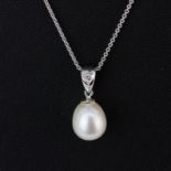 An 18ct white gold pearl and diamond set pendant on an 18ct white gold chain, L. 46cm.