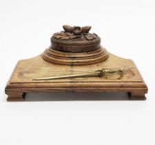 A carved oak desk stand, made from the wood of HMS Daedalus, W. 27cm, together with a brass naval