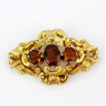 A large Victorian yellow metal (tested minimum 9ct gold) brooch set with three large oval amber