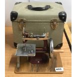 A cased miniature sewing machine.