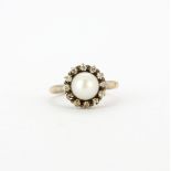 An antique 18ct yellow and white gold (stamped 18ct) cluster ring set with a pearl and old cut
