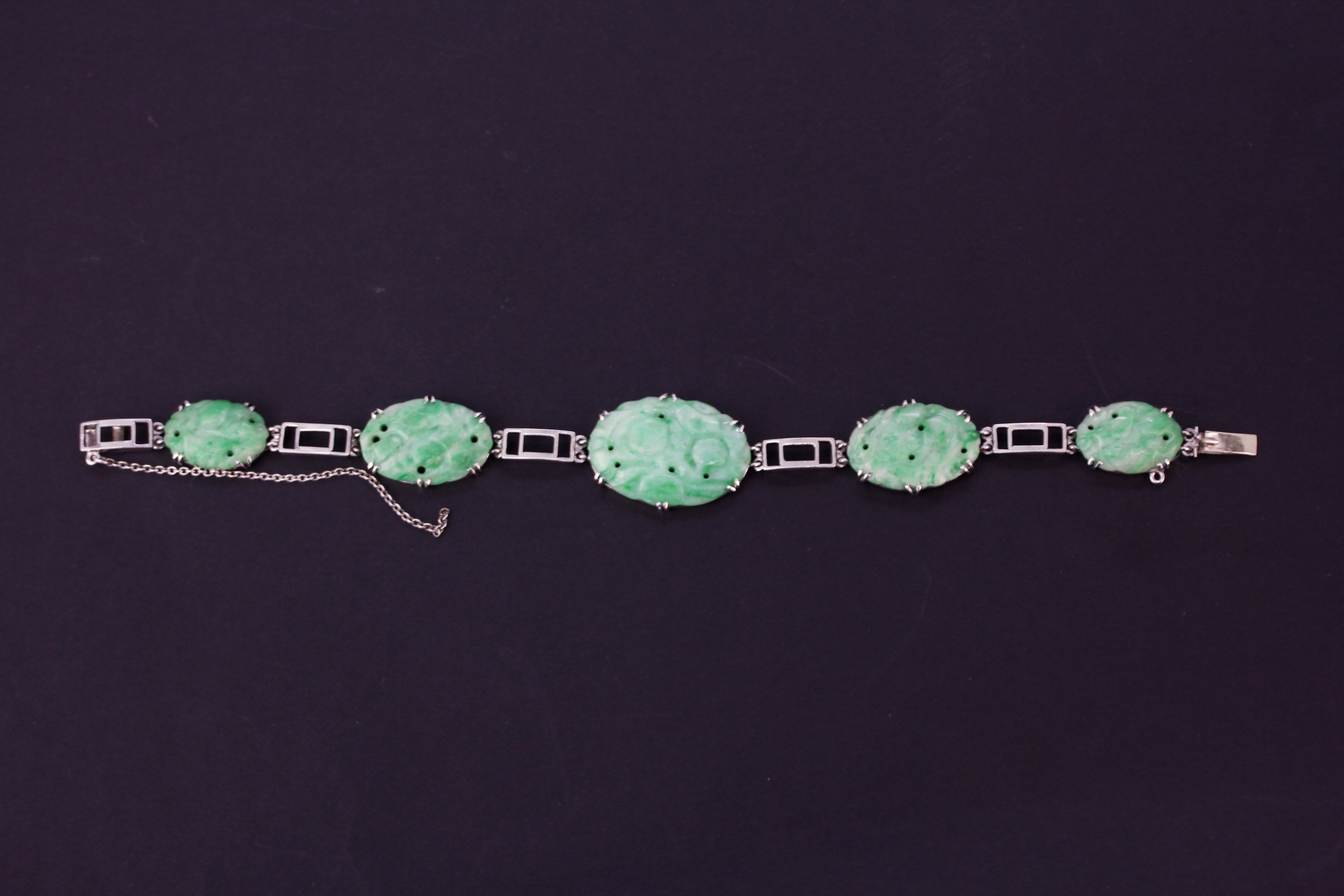 A white metal (tested high carat gold) bracelet set with carved jade, L. 23cm. - Image 4 of 4