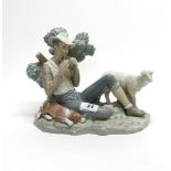 A large Lladro porcelain figurine of a Shepard playing pan pipes, H. 19cm, L. 28cm.