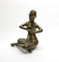 An early 20thC Himalayan bronze figure of a monk playing a flute, H. 31cm.