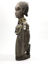 A large old, bleached, figured ebony tribal figure of a woman and child, H. 61cm, with bone bead