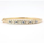 A 14ct yellow gold bangle set with rose cut diamonds and round cut sapphires, 6.5 x 6cm.