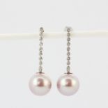 A pair of 18ct white gold (stamped 18K) drop earrings set with a large pink pearl and brilliant