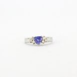 A 14ct white gold (stamped 14k) ring set with a trillion cut tanzanite and brilliant cut diamond set