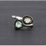 A 925 silver crossover ring set with opals and black spinels, (R ).