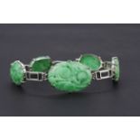 A white metal (tested high carat gold) bracelet set with carved jade, L. 23cm.