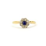 An 18ct yellow gold daisy cluster ring set with a round cut blue sapphire surrounded by white