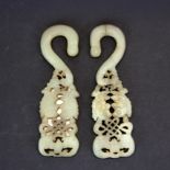 A pair of Chinese carved nephrite jade hooks decorated with fish, H. 10cm.