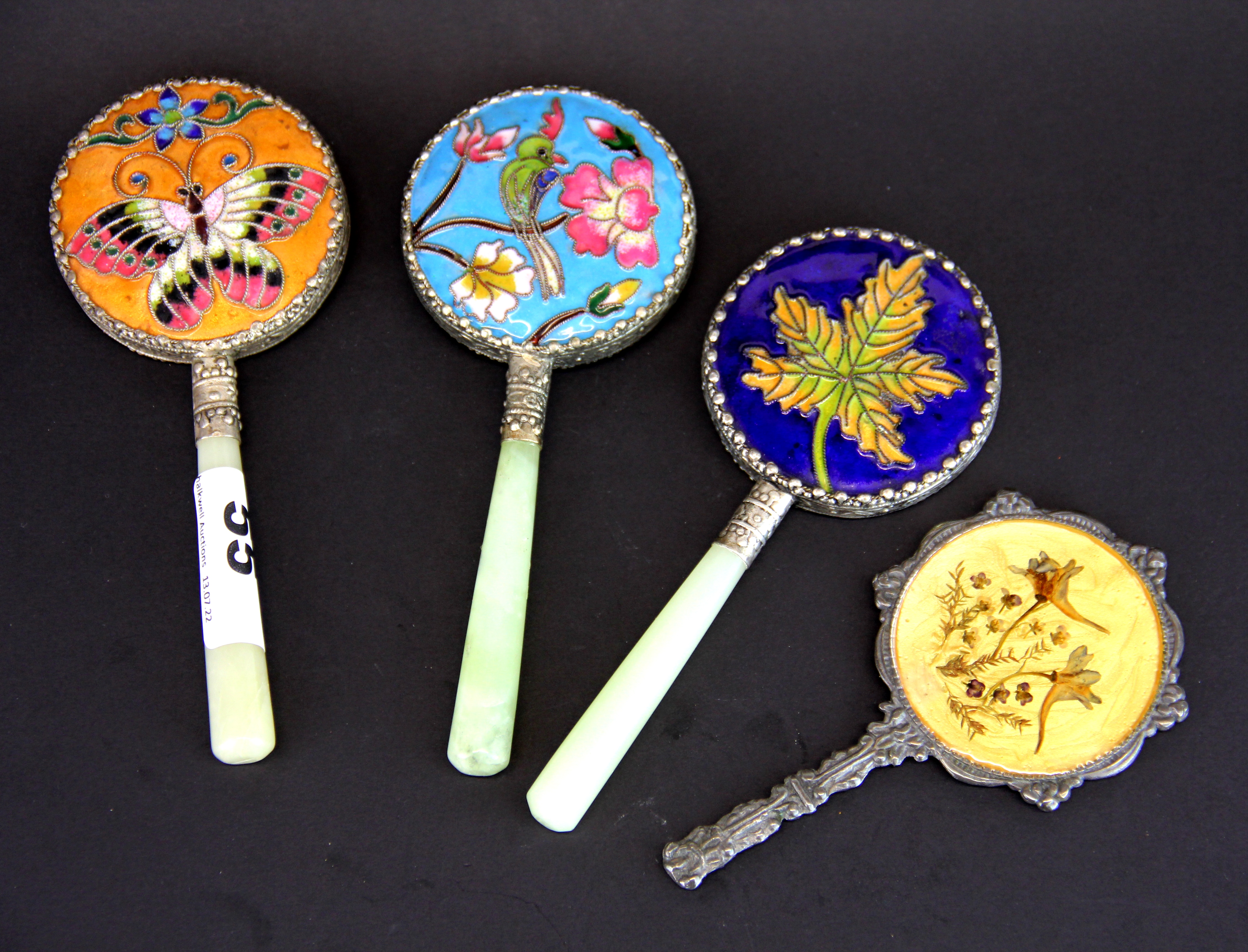 Three Chinese jade handled white metal and enamel hand mirrors, L. 15cm. with a further hand mirror.