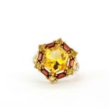 A 9ct yellow gold ring set with a fancy hexagonal cut citrine surrounded by baguette cut garnets and