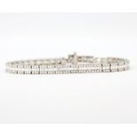 An 18ct white gold tennis bracelet set with brilliant and baguette cut diamonds, approx. 7ct total.