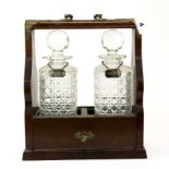 A mahogany and cut glass two bottle tantalus with silver labels, H. 30cm.