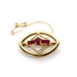 A matching yellow metal (tested minimum 9ct gold) brooch set with rubies, L. 3.2cm.