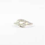 A white metal (tested 18ct gold) ring set with brilliant cut diamonds, (L.5).