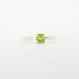 A 925 silver solitaire ring set with a round cut peridot, (R ).