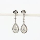 A pair of 18ct white gold drop earrings each set with a large pear cut diamond, approx. 1ct each,