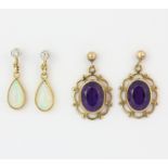 A pair of yellow metal (tested minimum 9ct gold) drop earrings each set with a diamond and a