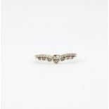 A hallmarked 9ct white gold diamond set wishbone ring, (M.5).