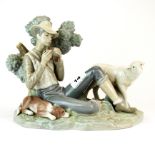 A large Lladro porcelain figurine of a Shepherd playing pan pipes, H. 19cm, L. 28cm. Tiny chip to