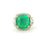 An 18ct white gold ring set with a large radiant cut Columbian emerald, 1.5 x 1.5cm, surrounded by