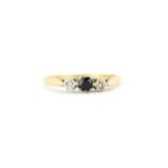 A yellow metal (worn hallmark, tested 18ct gold) ring set with a round cut sapphire and diamonds, (