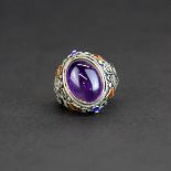 A Chinese silver and enamelled filigree ring set with cabochon amethyst, top W. 2.3cm.