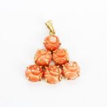 A 14ct yellow gold pendant set with carved coral roses, L. 3.7cm.