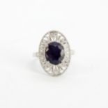 An 18ct white gold ring set with a large oval cut purple sapphire, approx. 3.45ct, surrounded by