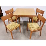 A 1960's golden oak G-plan style draw leaf table and four chairs, 84 x 76cm.