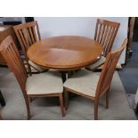 A 1980's G-plan extending circular dining table and four chairs, Dia. 105cm.