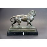 A cast bronze figure of a lion after Ch. Valton on a black marble base, W. 26cm. H. 20cm.