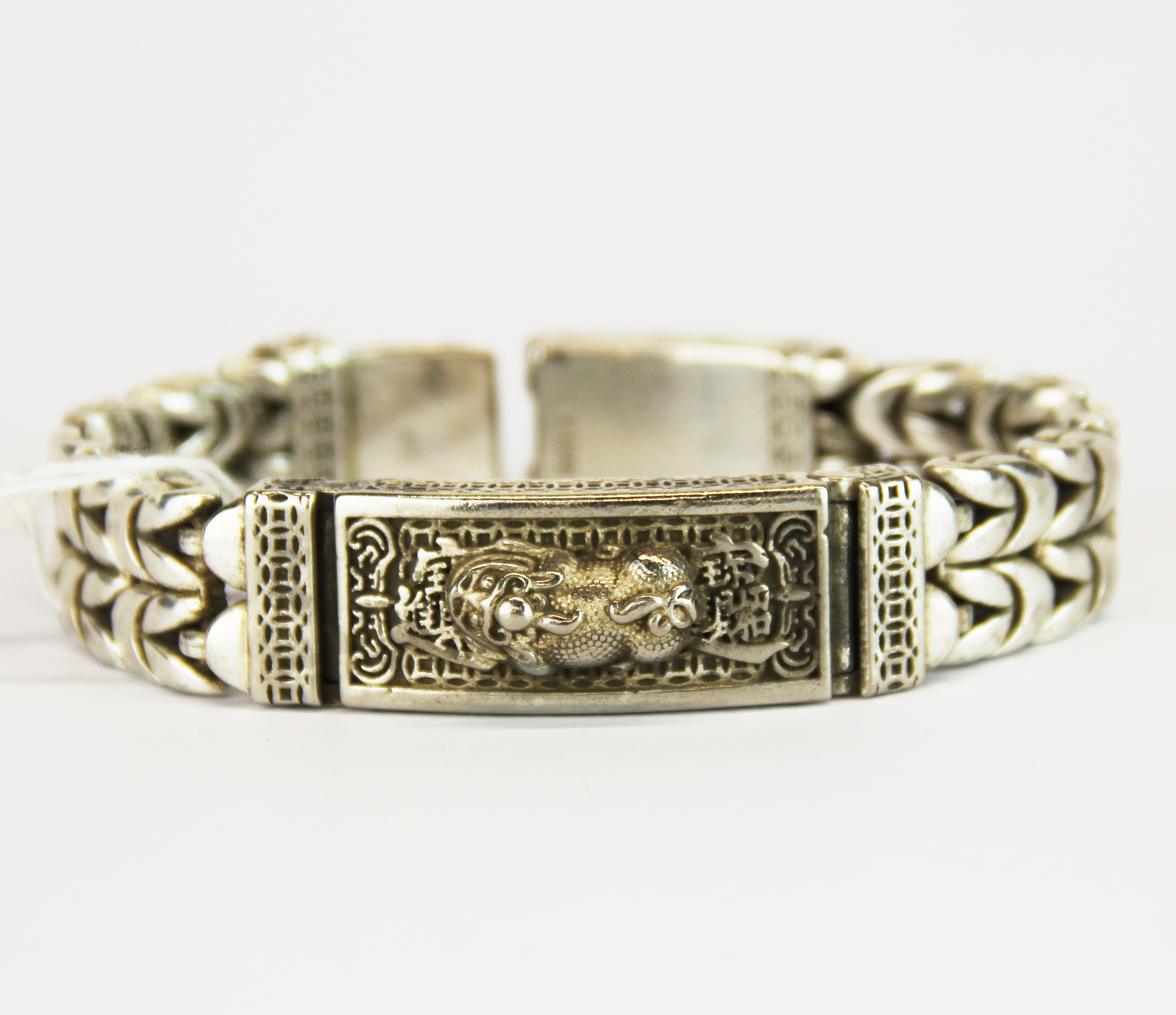 A heavy Chinese white metal mans bracelet featuring a lion dog, W. 1.5cm. Bracelet L. 21cm.