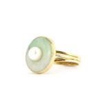 A 14ct yellow gold ring set with a natural jade disc and a cultured pearl, ring size, (N).