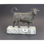 A bronze figure of a bull on a reconstituted marble base, H. 19cm. W. 23cm.