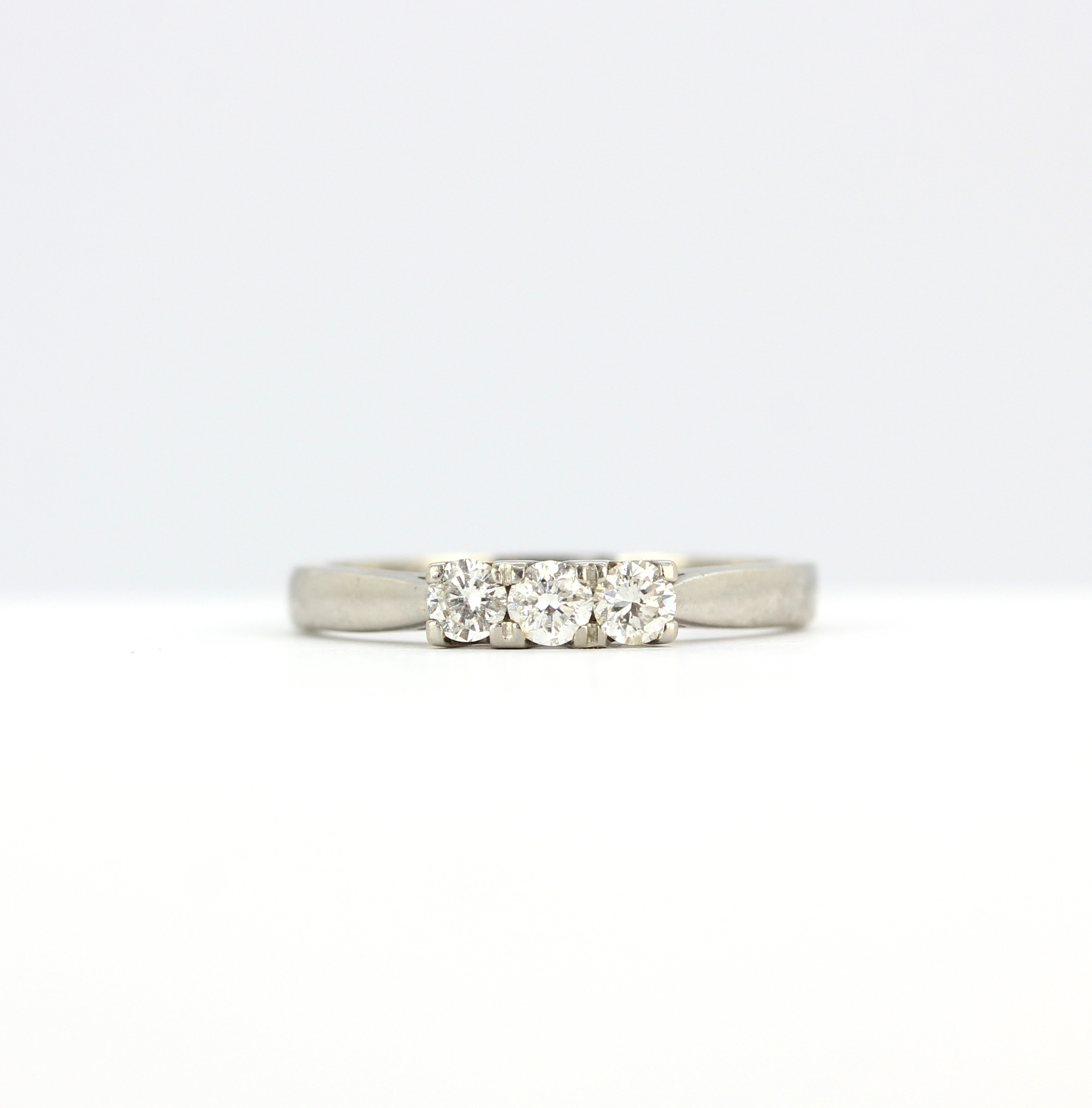 An 18ct white gold and platinum ring set with three brilliant cut diamonds, (N).