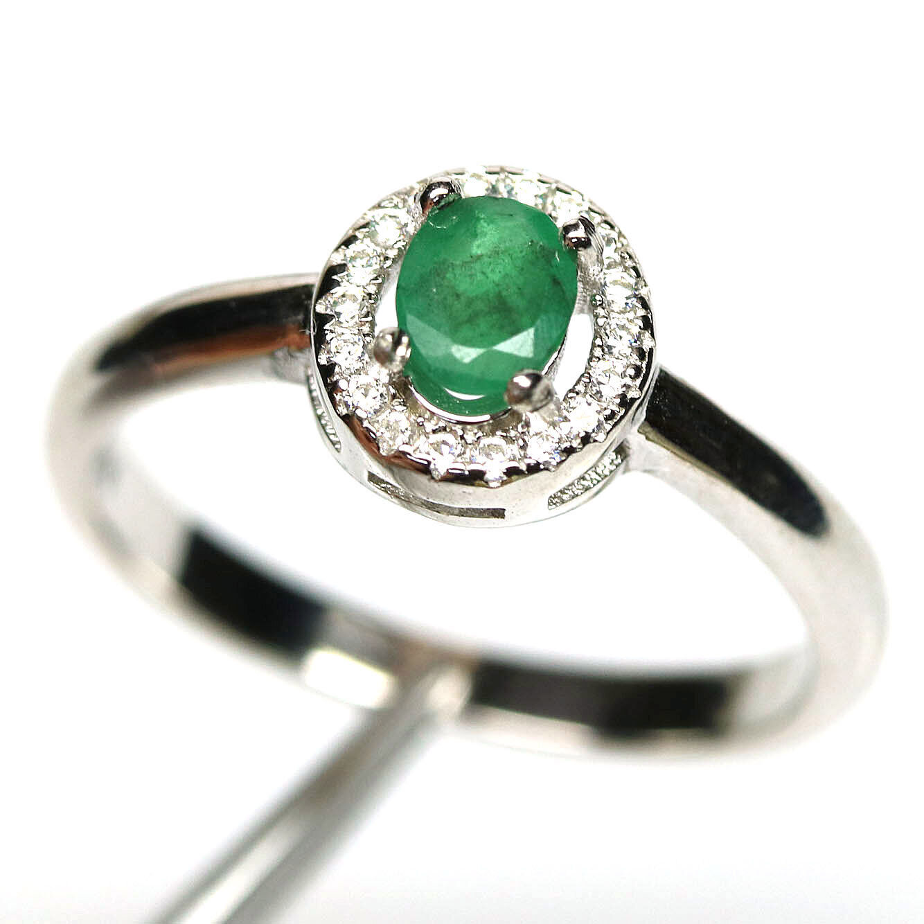 A 925 silver cluster ring set with an oval cut emerald surrounded by white stones, (N.5).