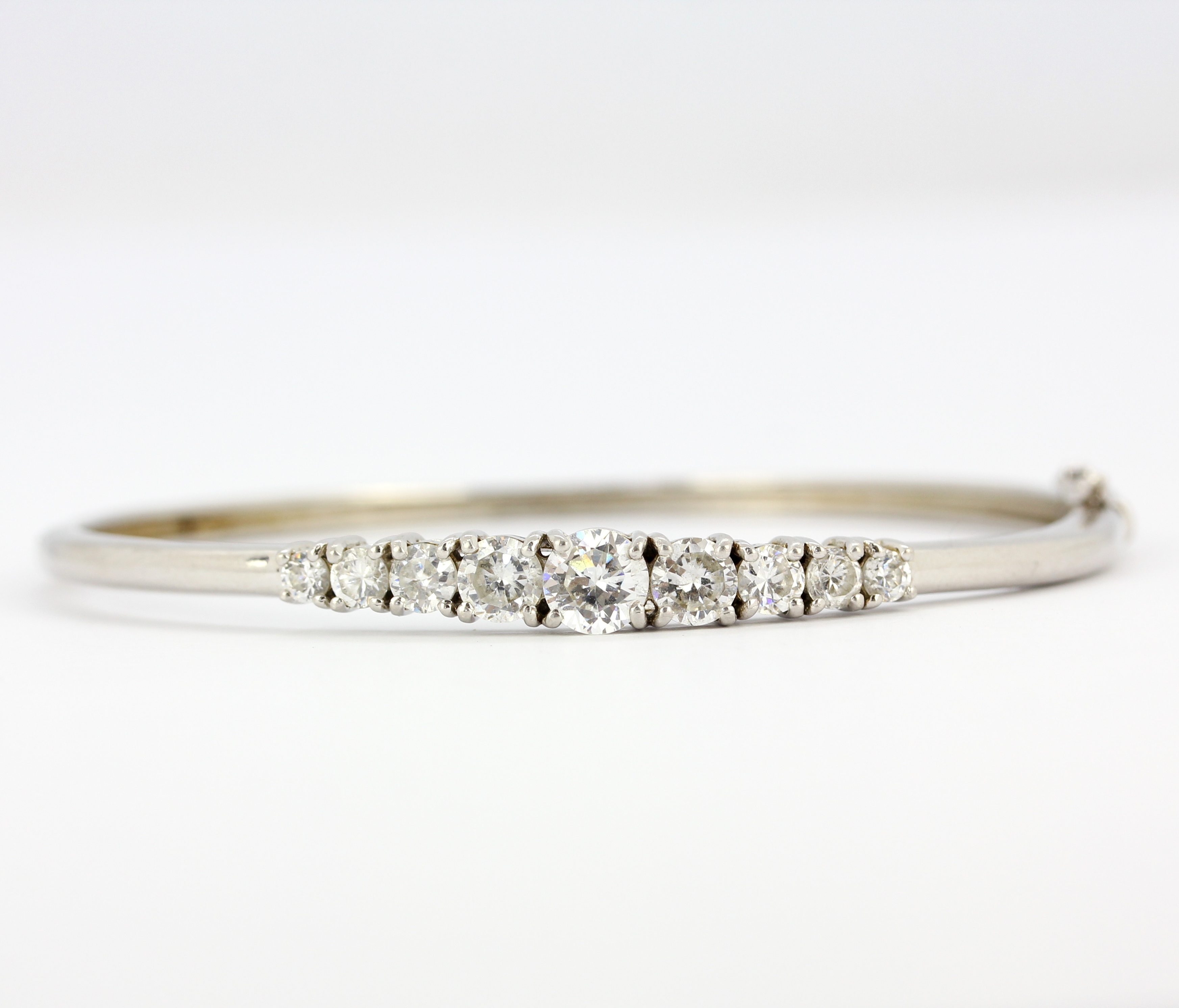 A 925 silver bangle set with graduated round cut cubic zirconias, dia. 6.5cm.