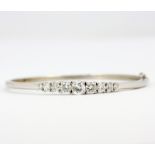 A 925 silver bangle set with graduated round cut cubic zirconias, dia. 6.5cm.